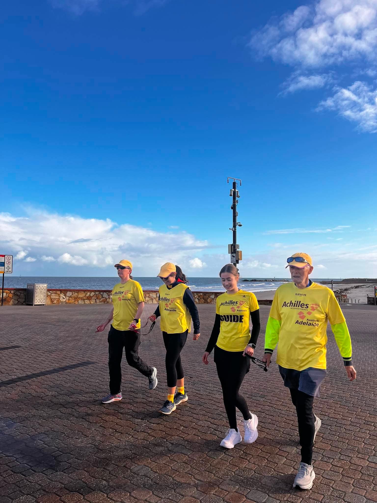 Cassie Emma Georgie and Tony walking along the esplanade